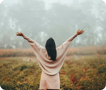 Person raising arms in nature symbolizing emotional recovery